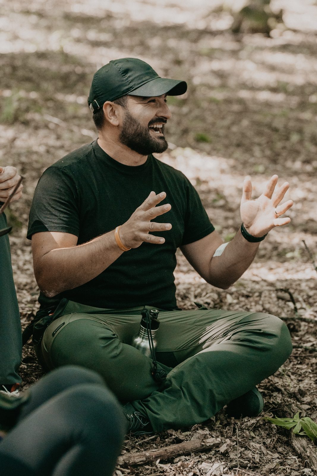 Ein Teilnehmer des Teamleiterkurses lacht während einer Übung im Wald.